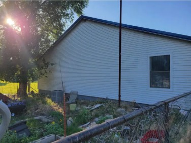 South facing wall of white house on a small Kansas homestead showing height for bat house mounting